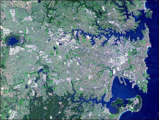 Фотография Сиднея, сделанная из космоса. В верхней правой части снимка виден протяженный и извилистый залив Порт-Джексон. В нижней части располагается залив Ботани-Бей.