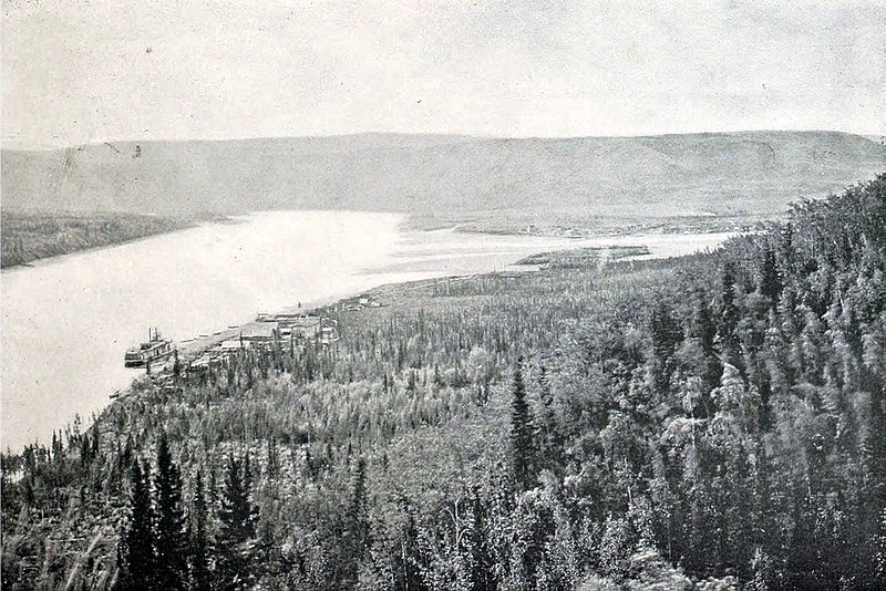 Река Фортимайл впадает в Юкон, фото 1897 года. На переднем плане около парохода расположен Форт-Кудахи, вдали виднеется Форти-Майл.